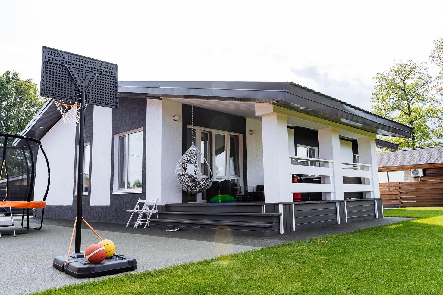 In front of a house, there is a basketball hoop installed, which adds a recreational element to the property, inviting fun and activity for those living there as well as visitors photo