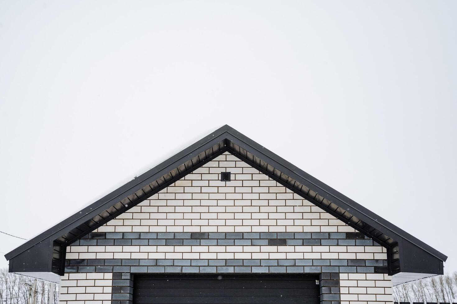 Experience the breathtaking architectural design of a modern brick house set against a picturesque winter landscape, showcasing the beauty of contemporary construction photo