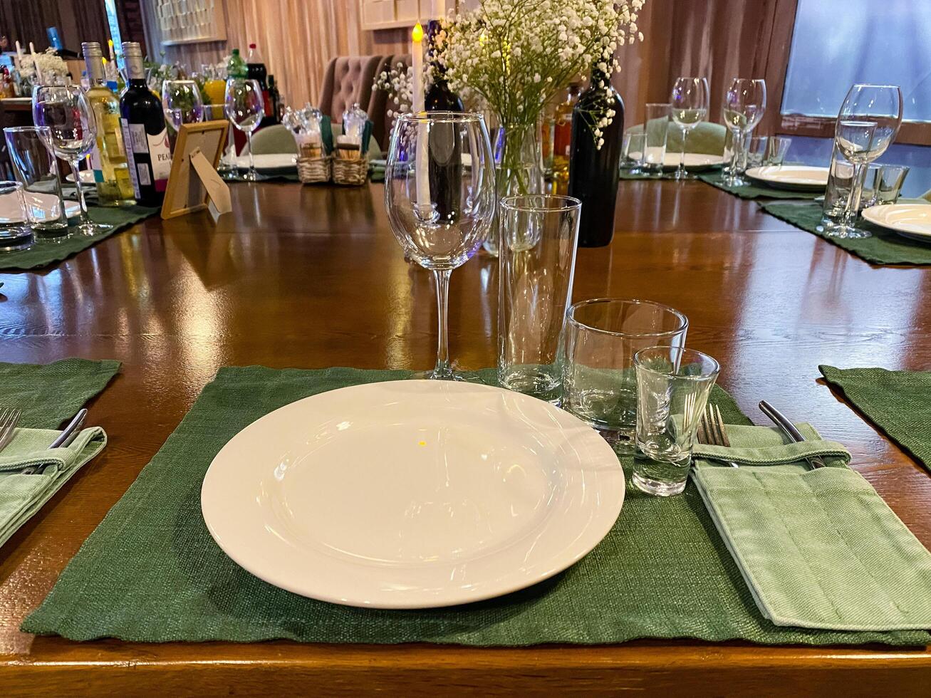 A table setting with a white plate on a vibrant green mat photo