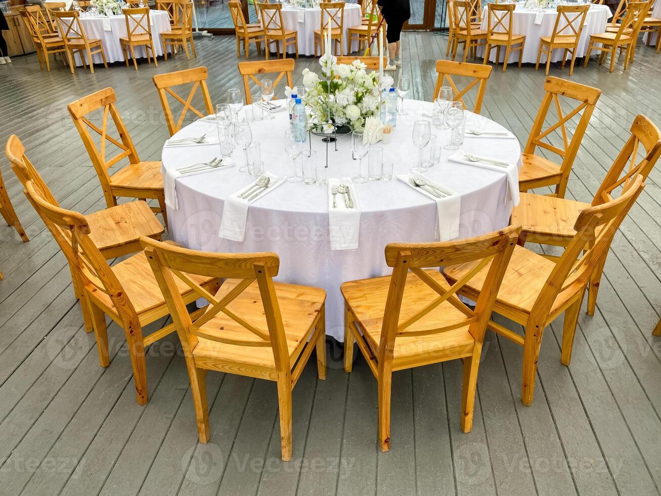 An elegant round dining table set designed specifically for events, featuring a charming floral centerpiece that enhances the overall ambiance photo