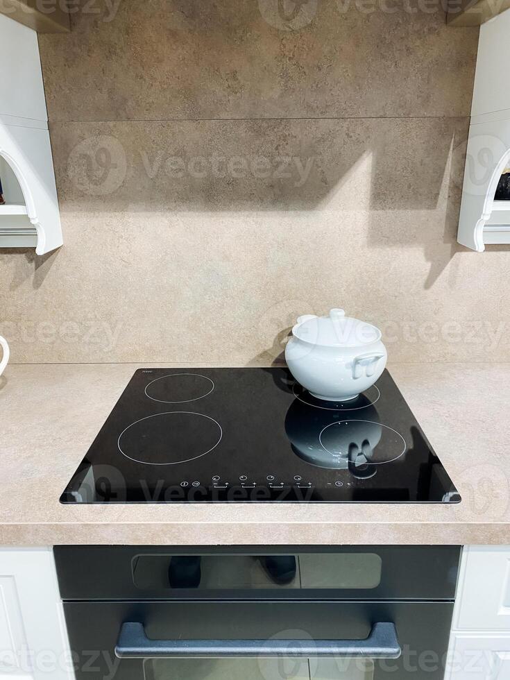 At this moment, a cooking pot is placed on a stove inside the kitchen, a designated space that facilitates the essential activities of cooking and meal preparation in a residential setting photo