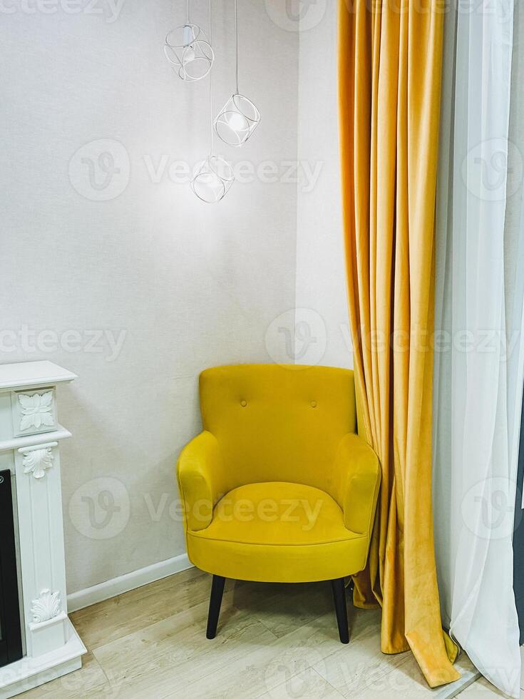 In a cozy corner of a welldecorated room, there is a bright yellow chair that is resting peacefully next to a charming fireplace, adding a delightful pop of color and comfort to the space photo