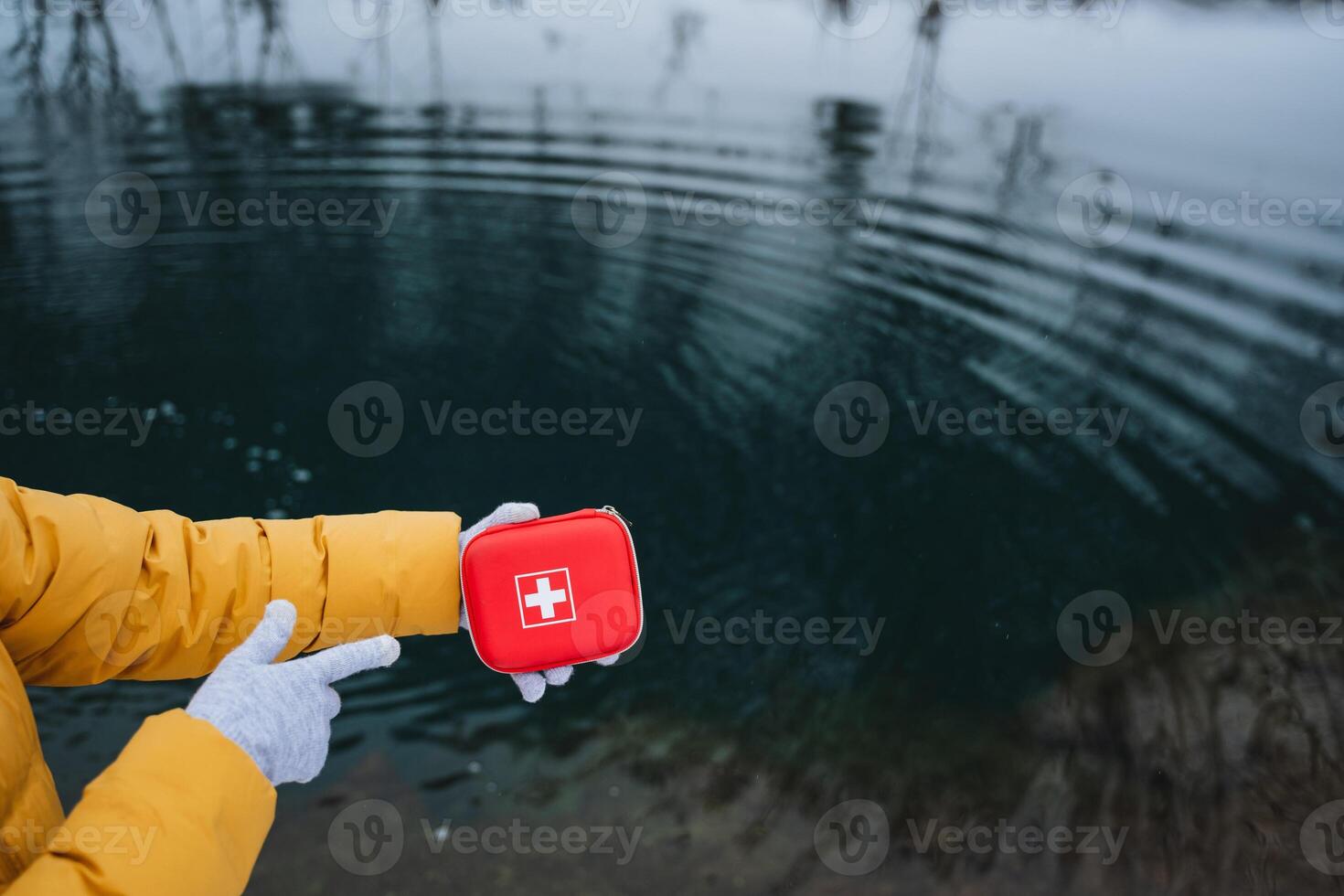 Emergency Preparedness A Person Holding a First Aid Kit Beside the Waters Edge on a Foggy Day, Ready to Provide Assistance if Necessary to Ensure Safety and Care photo