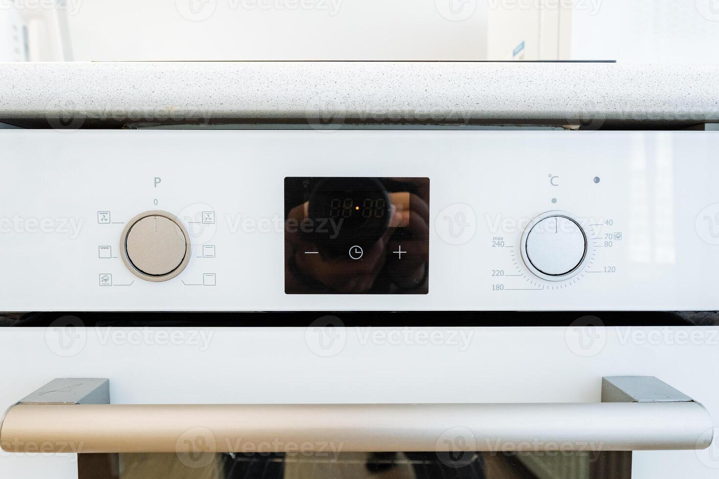 Modern white kitchen oven with digital display and stainless steel handles is a sleek addition to contemporary kitchens. Convenient, efficient, and perfect for cooking and baking photo