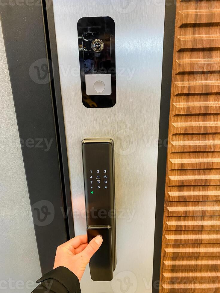 An individual is pressing down on a button located on an electronic door lock, which is designed to manage secure access by allowing or denying entry at critical points within a building photo