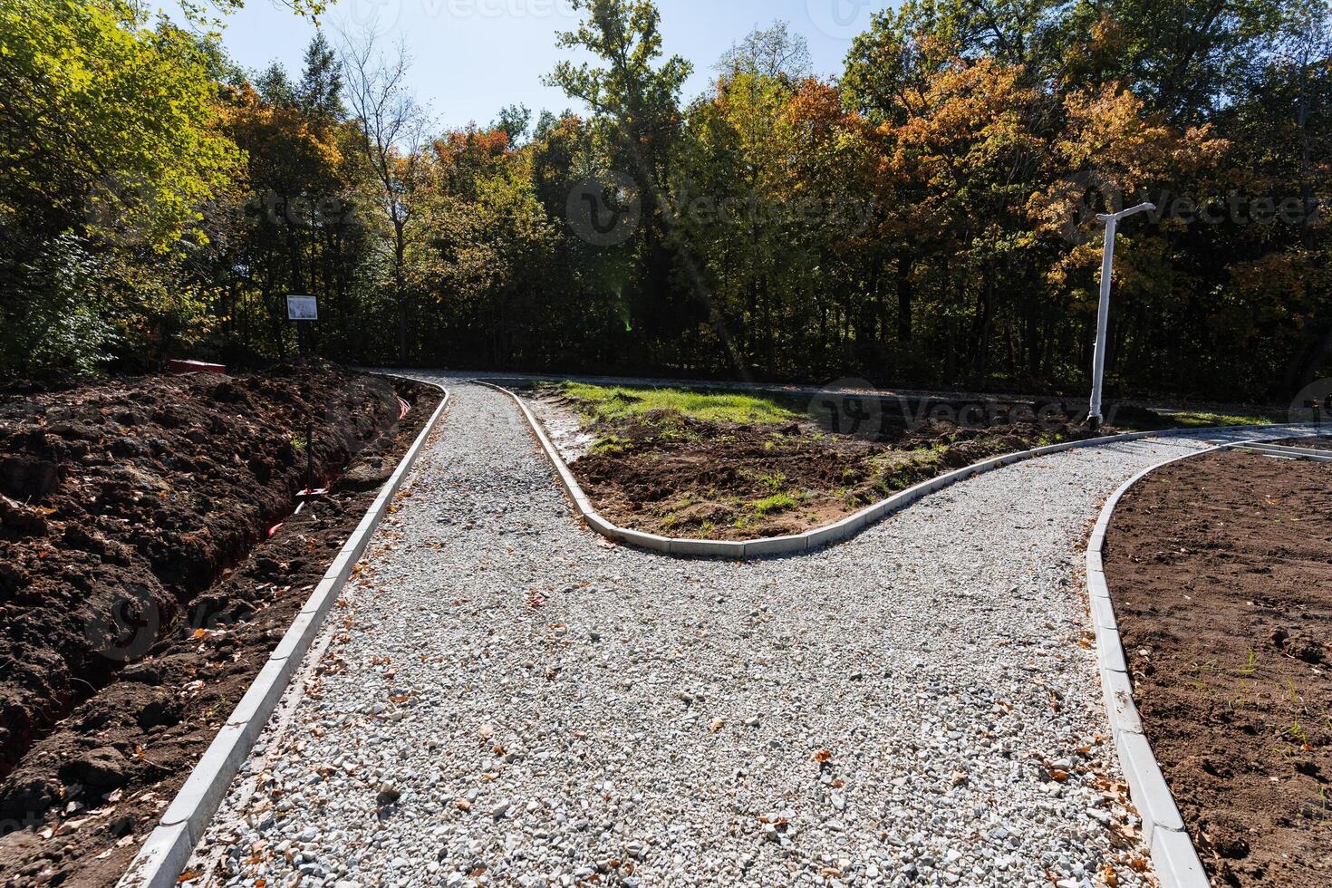 A beautifully curved pathway is currently under construction, framed by lush trees and vibrant nature all around, enhancing the scenery photo