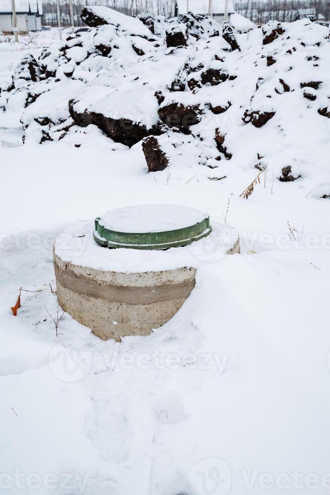 In the center of a vast, snowcovered field, there is an incongruous sight a solitary toilet, standing amidst the winter wonderland of frozen ice and frosty precipitation photo