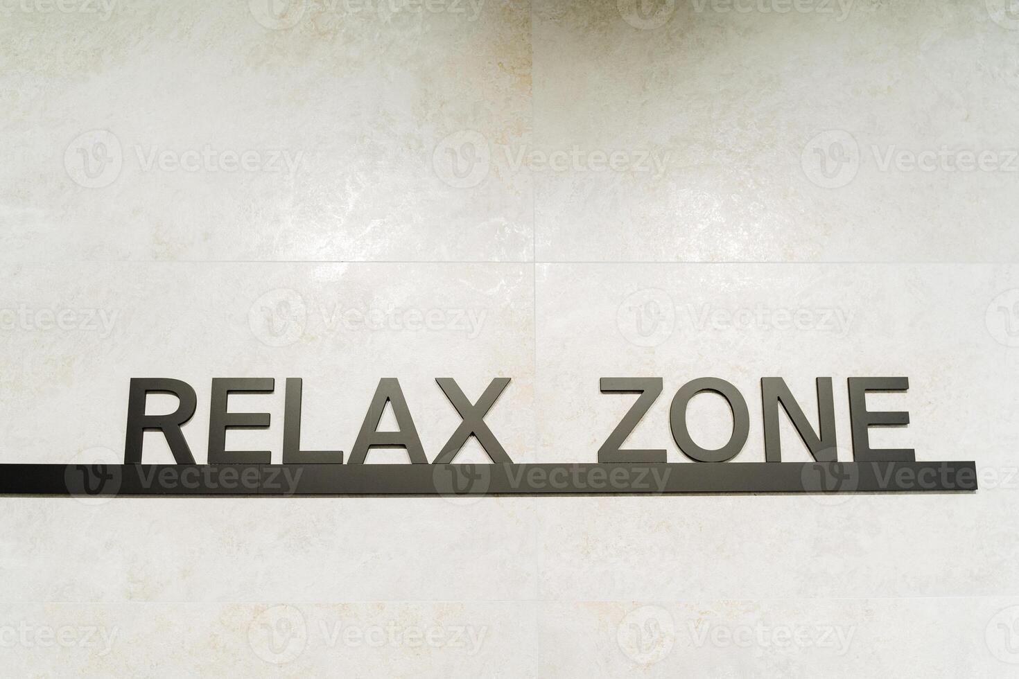 Rectangular relax zone sign with artistic font and graphics on a wall, possibly related to a brand or automotive theme. Keywords Rectangle, Font, Art, Brand, Automotive photo