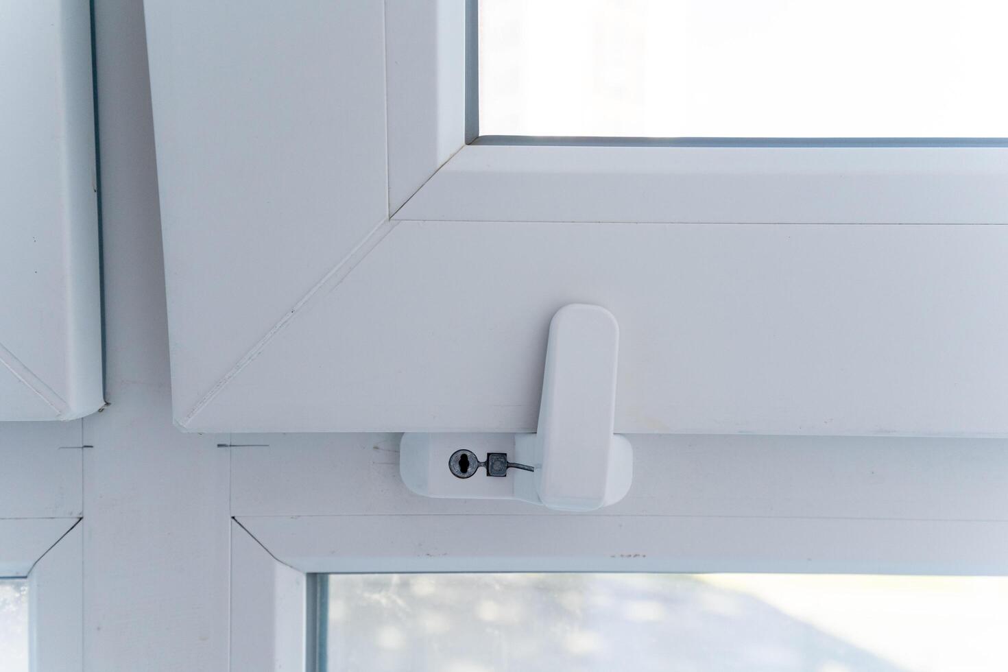 This image showcases a detailed closeup view of a pristine white window that features a secure lock on it, emphasizing its design and practicality in terms of safety and functionality photo