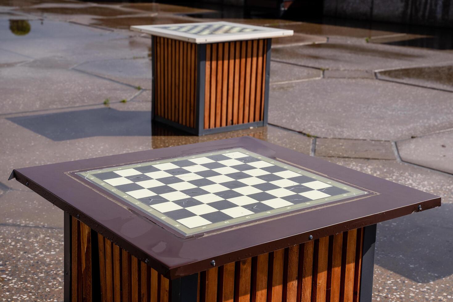 A classic chess board is elegantly placed on a sturdy wooden table outside, enhancing the natural beauty of the surroundings while providing a perfect setup for a game of strategy photo