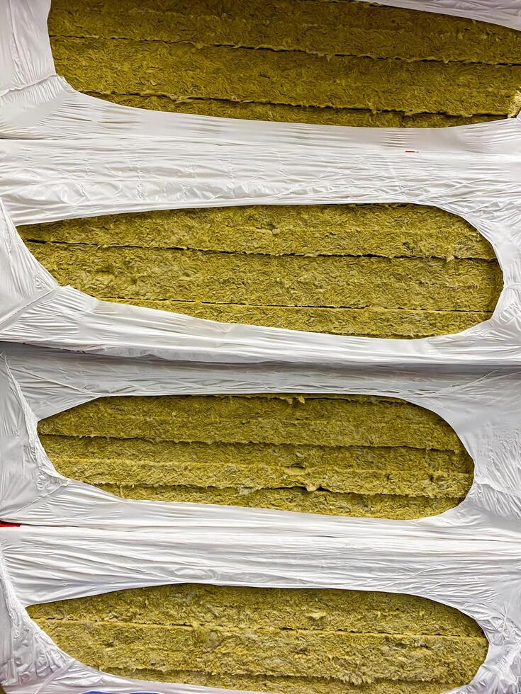 The image shows a neatly stacked pile of highquality rock wool insulation, securely packed in durable plastic bags for safe storage, easy handling, and convenient transport photo