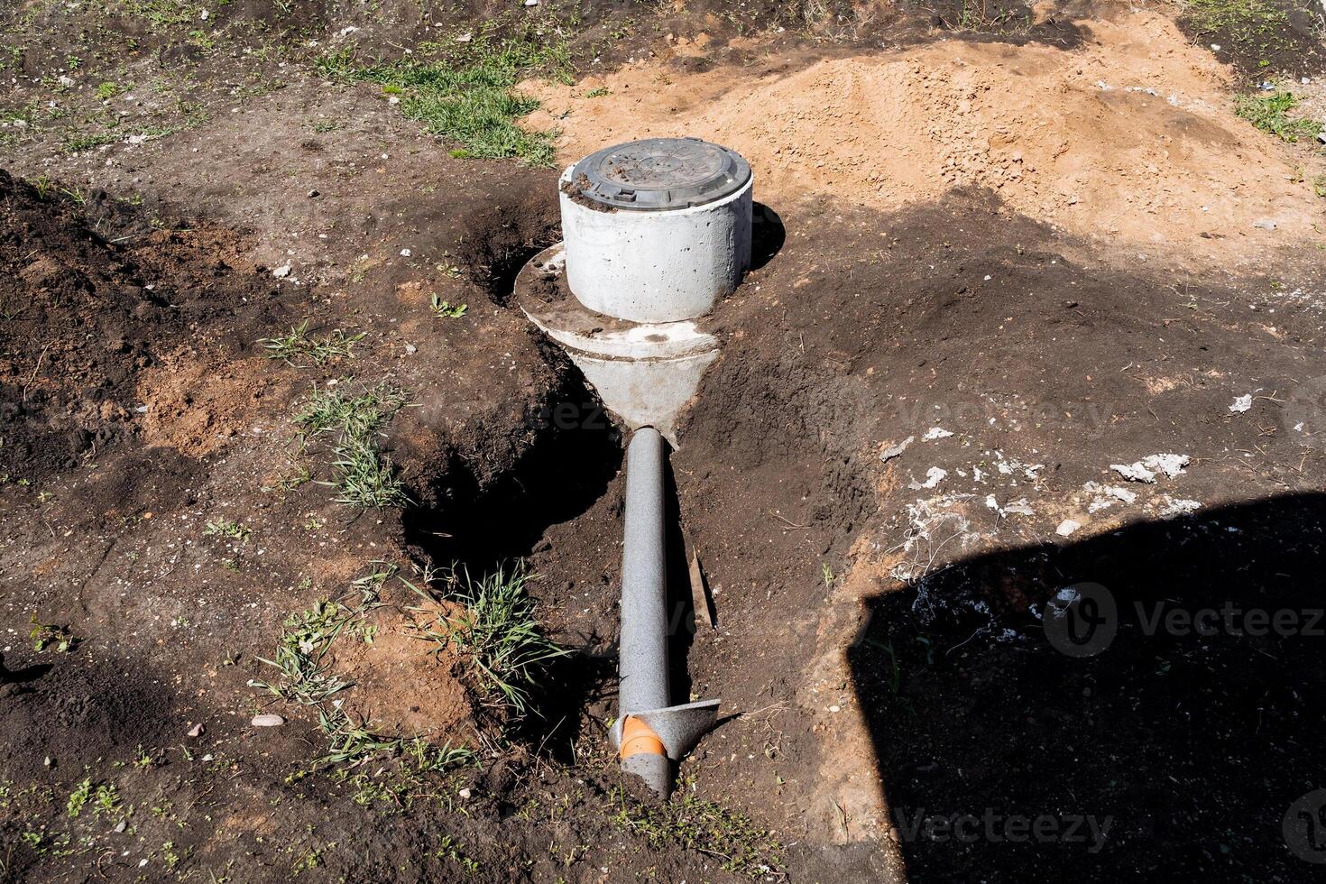 Pipe protrudes from hole, used for watering plants in landscape photo