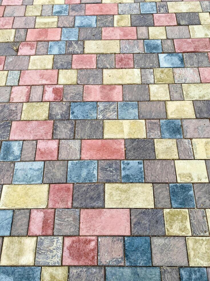 The intricately designed brick pavement enhances the cityscape with vivid colors, symmetry, and charm, elevating its visual appeal and artistic value with its carefully crafted pattern photo