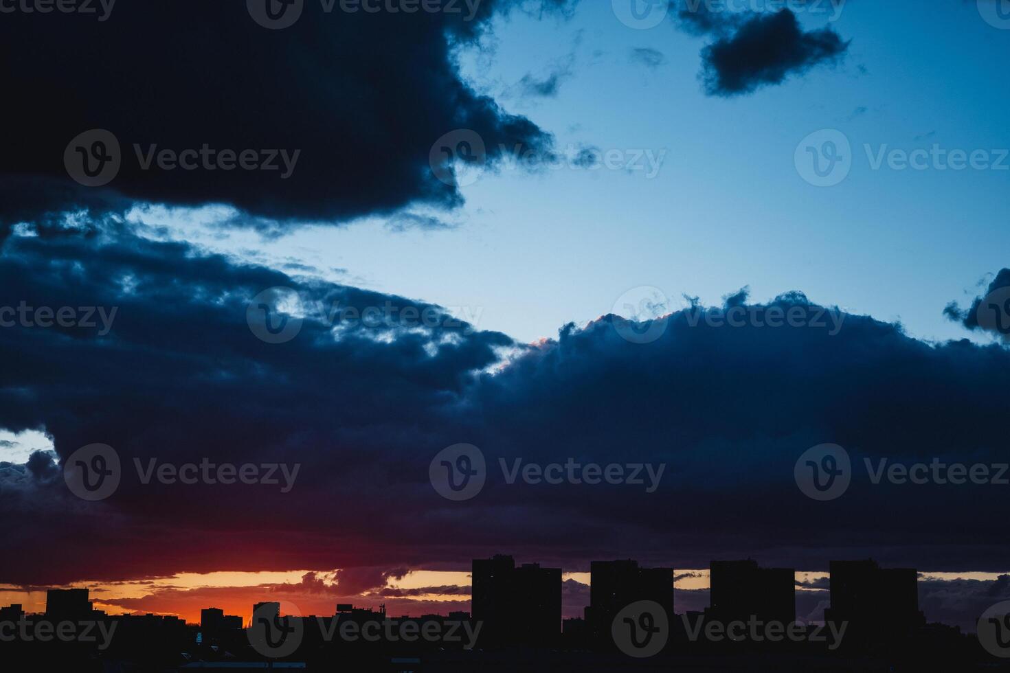 City skyline silhouetted against cloudy sky at sunset photo