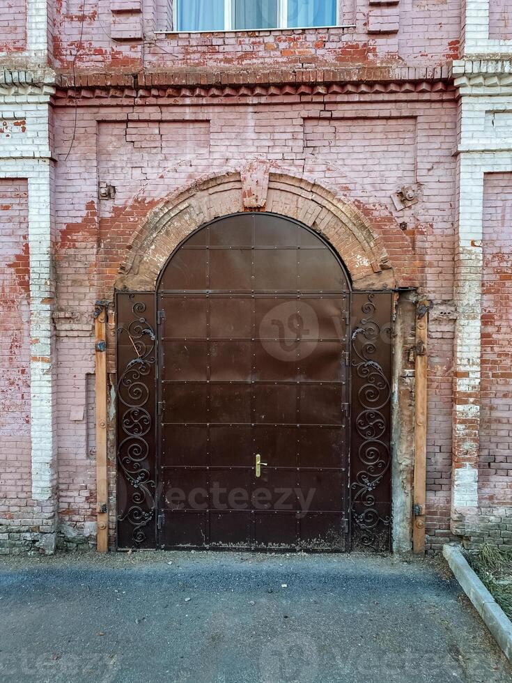 The brick building, known for its durability and sturdiness, showcases a lovely brown door and a beautifully crafted window, highlighting classic architectural elements and timeless style photo