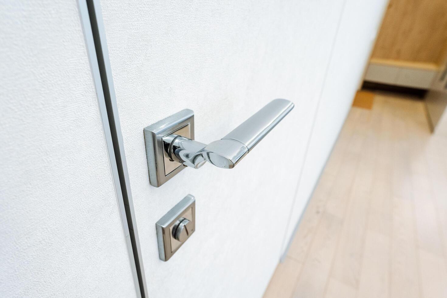 A closeup view of a door handle on a white door highlights the intricate design and features. The image showcases the beauty of the wood and the craftsmanship of the handle photo