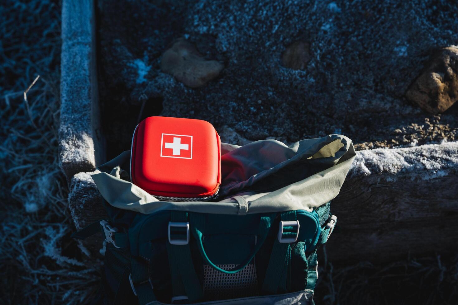 The red box of the first aid kit with medicines is in the backpack of the tourist, essential equipment, a mini first aid kit, a hard box. photo