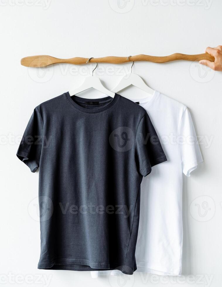 Two tshirts on a clothes hanger, one in electric blue, on a wooden rack photo