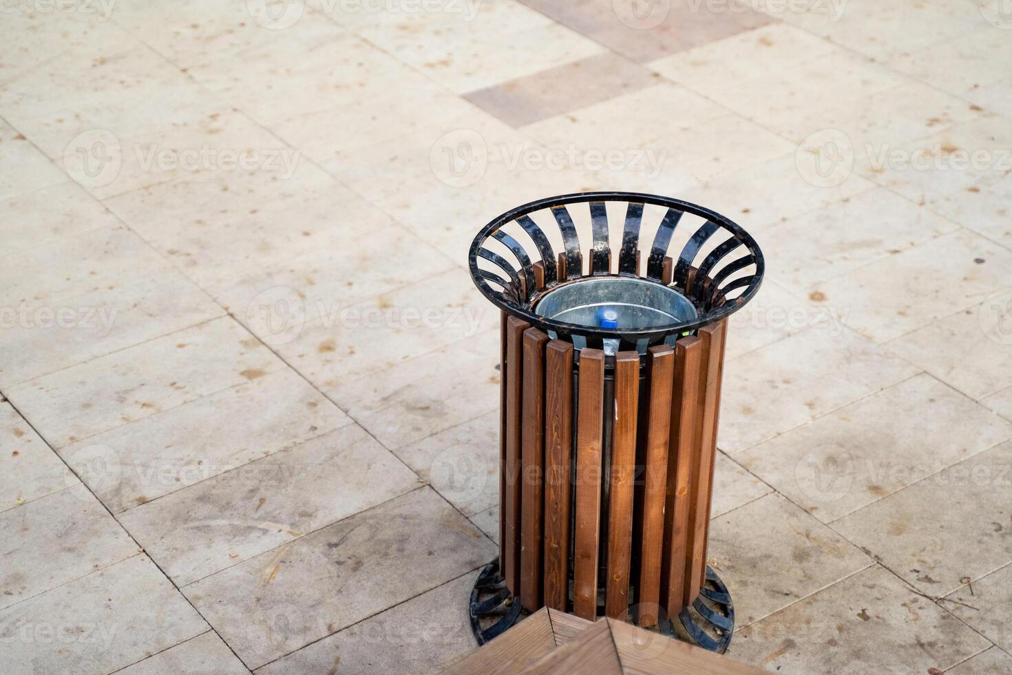 A wooden trash can is currently placed on a beautifully designed tiled floor, adding a rustic touch to the overall aesthetics of the space while serving its purpose effectively photo