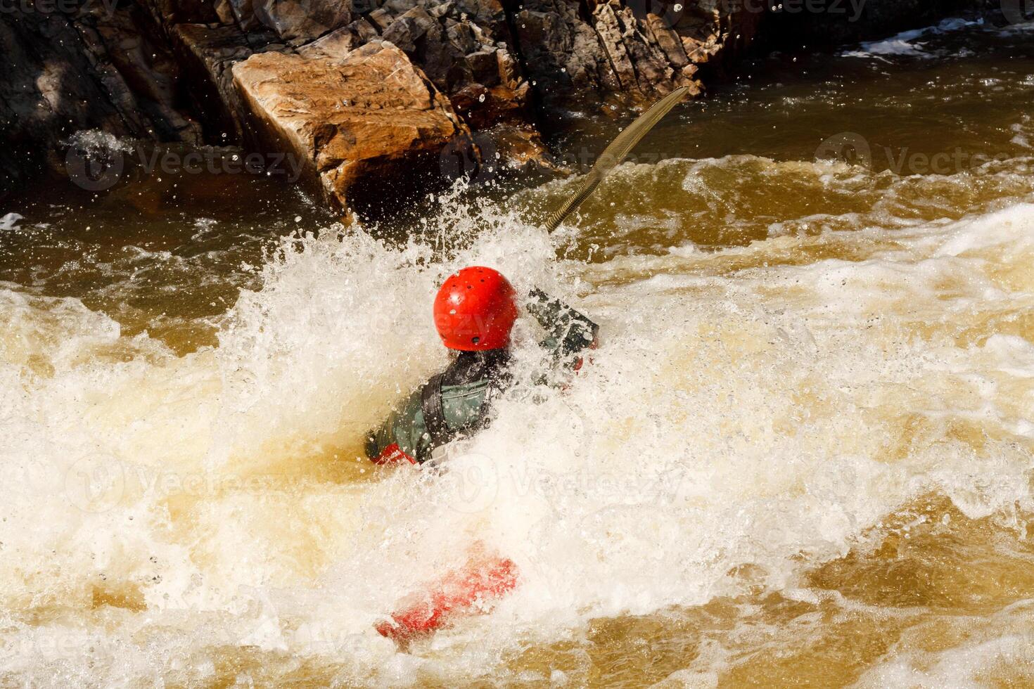 A Person In A Red Helmet Is Swimming In A River photo