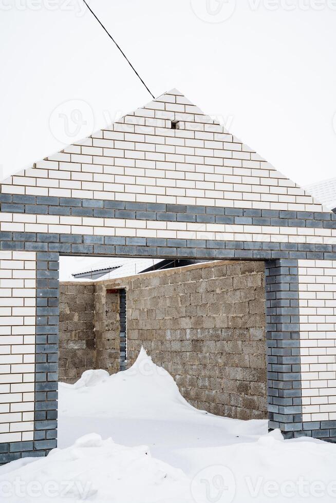 A sturdy brick building stands tall in winter, its roof blanketed in glistening snow, creating a picturesque scene that showcases the charm and tranquility of the season photo