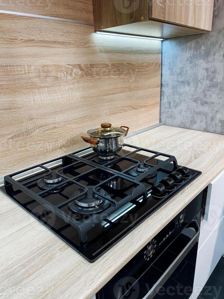 A typical kitchen typically includes a stove powered by gas, complete with a pot sitting on top, emphasizing the common culinary tools and appliances frequently found in home environments photo