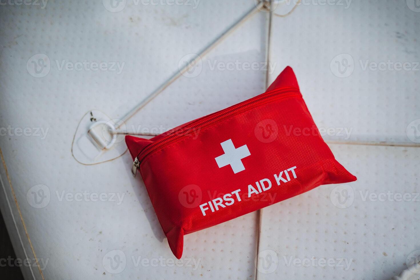 The first aid kit is red in color and prominently features a white cross symbol on its exterior, making it easily recognizable for emergency situations and healthrelated needs photo