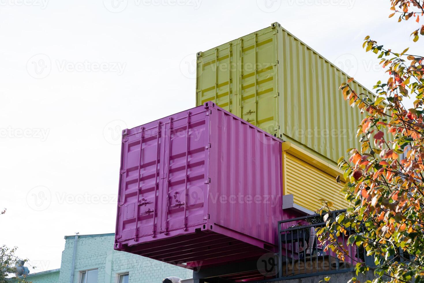 A vibrant pink container along with a striking green shipping container has been carefully stacked on top of one another, creating a unique and intriguing visual feature photo