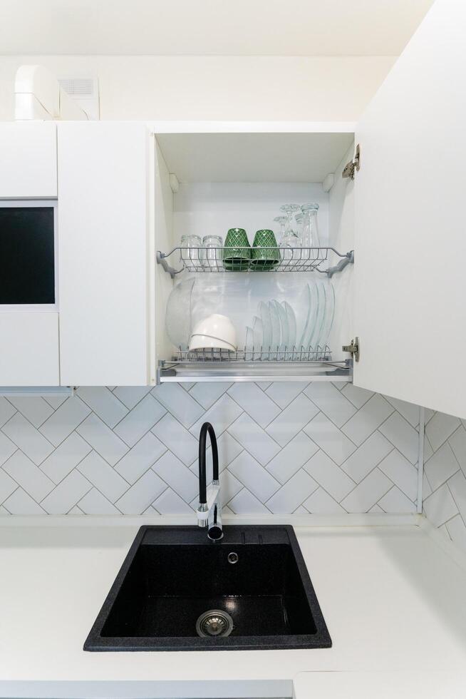 A kitchen with a sink, faucet, and drying rack for convenience photo