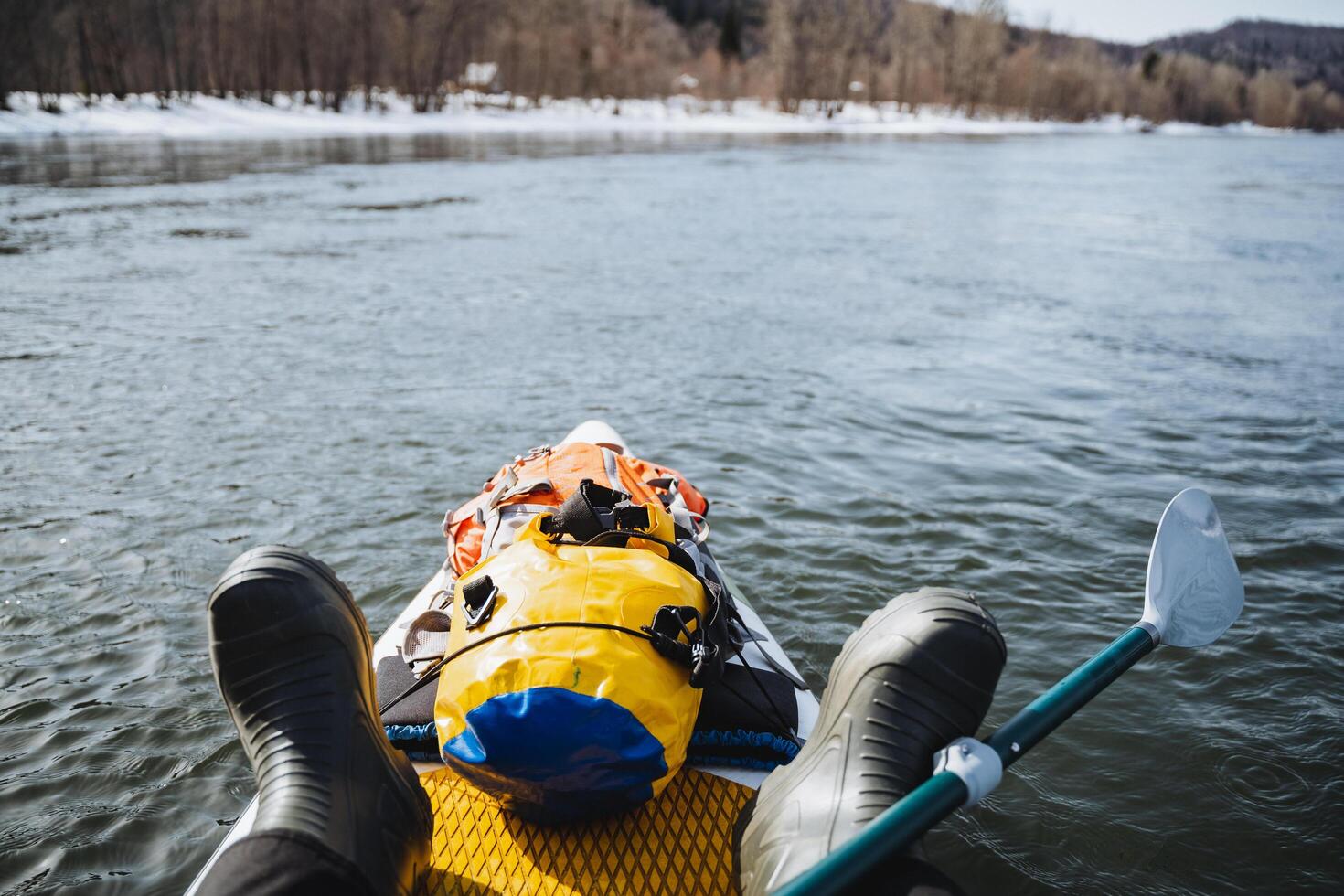 SUP boarding on the river, hiking equipment, water adventure, dry bag fixed on the bow of the boat, paddle for rowing. photo