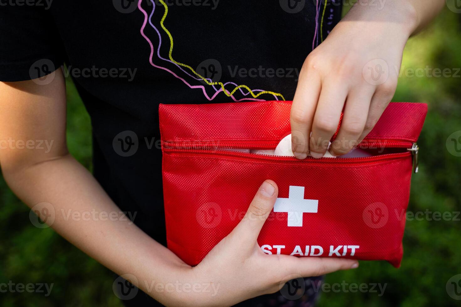 A person is firmly holding a first aid kit in their hands, showcasing a sense of preparedness and care, ready to assist anyone in need of medical attention in this moment photo