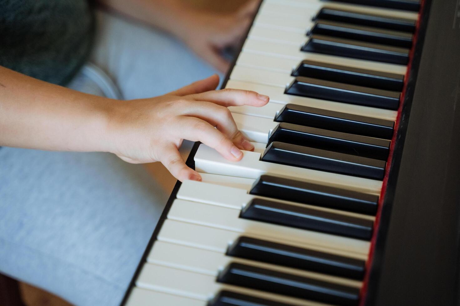 A person is playing a piano with their hand on the keys photo