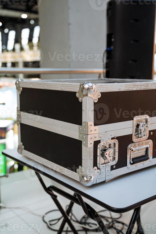 A highquality Professional Equipment Case is showcased on a modern table at a busy venue, highlighting its innovative design and durability for various events photo