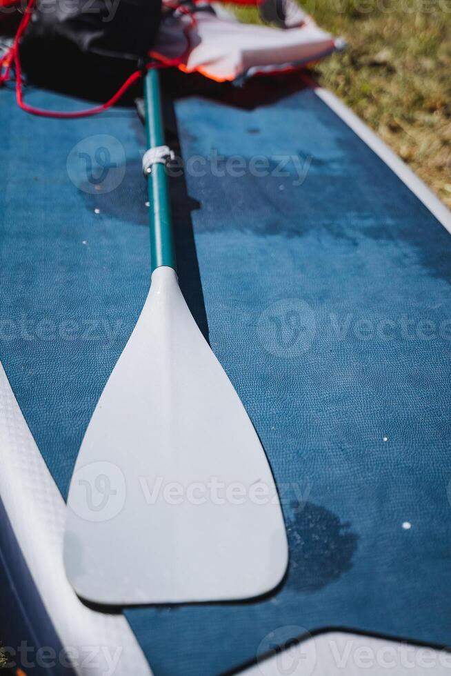 Enjoy a lakeside adventure with paddleboarding, safety gear, and natures beauty. Have a fun outdoor time on the water with paddleboarding and appreciate the scenic surroundings photo