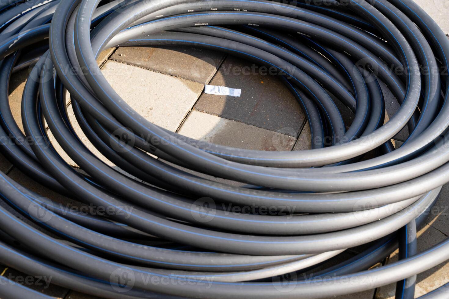 A large collection of various wires and cables are organized and stacked on top of each other on a table, creating an intriguing display of electrical wiring components and supplies photo