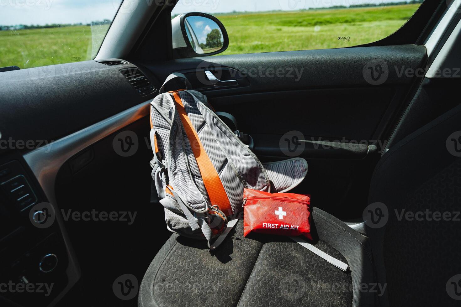 In the back seat of the car, a wellorganized backpack and a first aid kit show emergency readiness while traveling, emphasizing the vehicles preparedness for any unforeseen situations photo