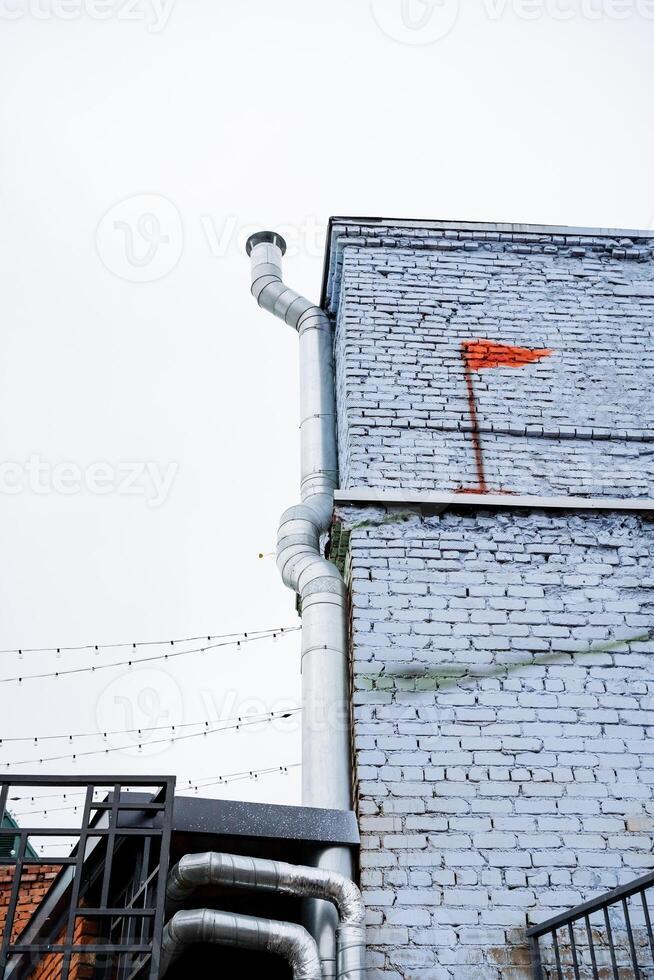 A vividly bright red flag is prominently painted on the side of a building, making it easily visible from afar and creating a striking and memorable visual against the urban city backdrop photo