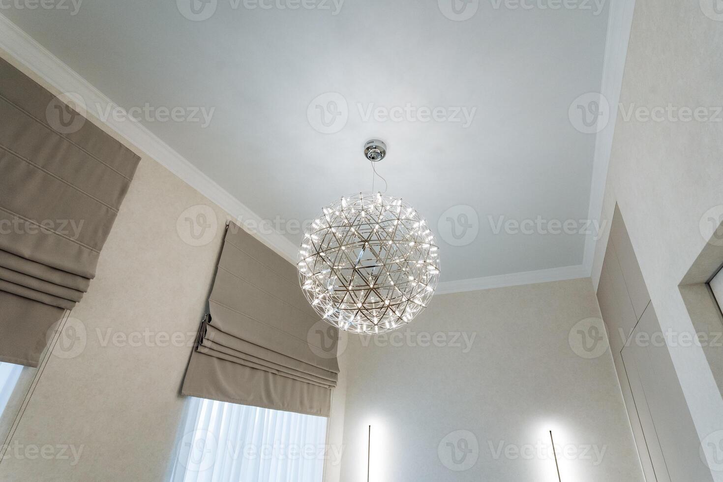 Enhance your living space with a chic chandelier and a neutral color palette in this elegantly designed modern room, creating a sophisticated and stylish ambiance photo