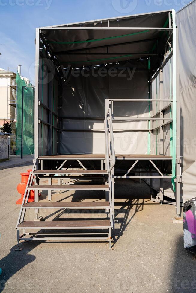 In a spacious parking lot, there is a trailer that features a set of stairs leading up to its entrance, making it accessible for individuals to enter and exit comfortably photo