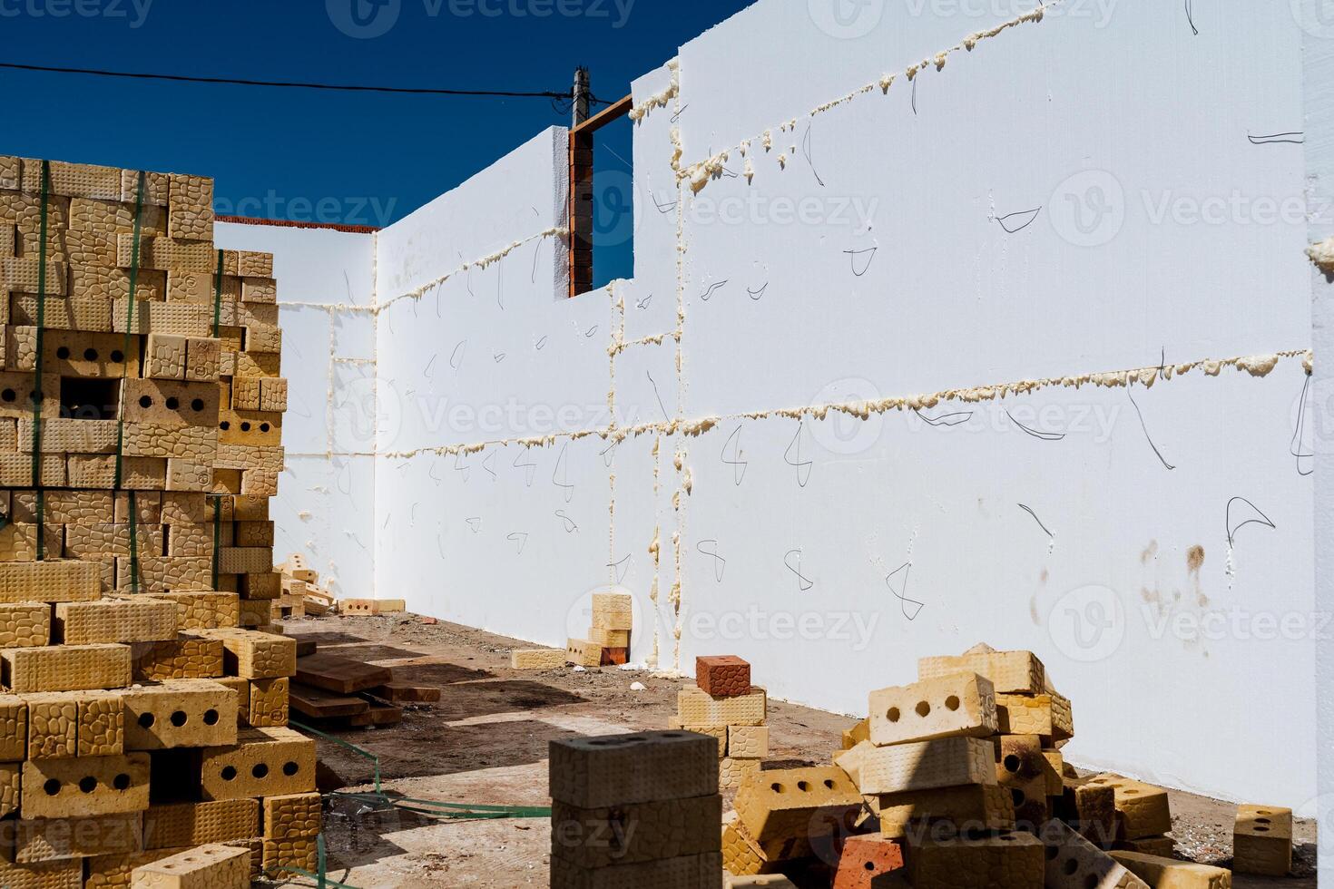 The construction site displays yellow bricks and concrete walls, showcasing the ongoing development of a building. It illustrates the incomplete state of the project photo