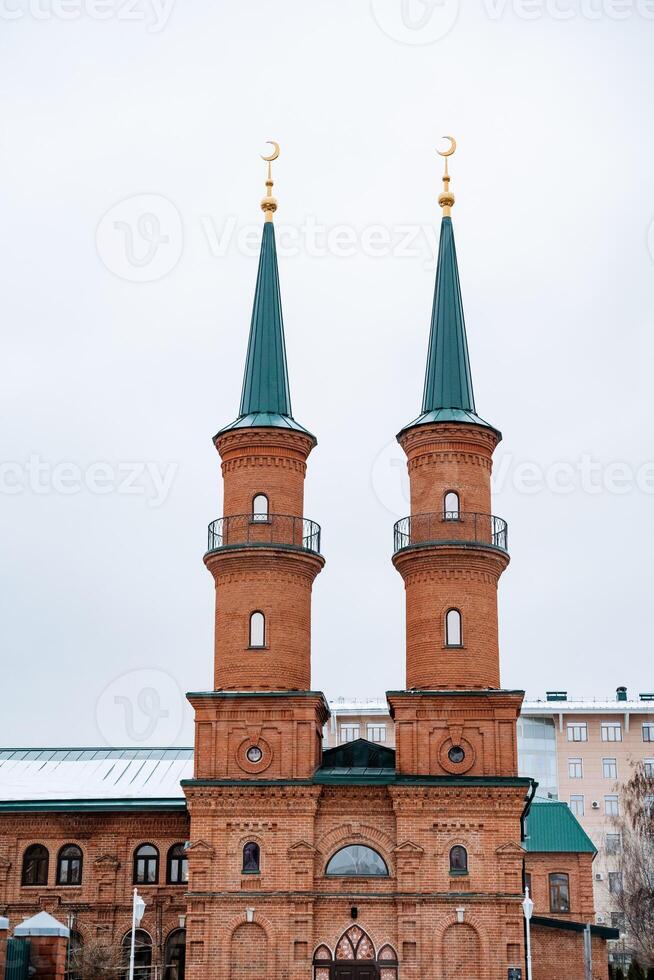 There is a brick building that features two elegant minaret towers gracefully positioned on top of it, showcasing its stunning architectural design and historical significance photo