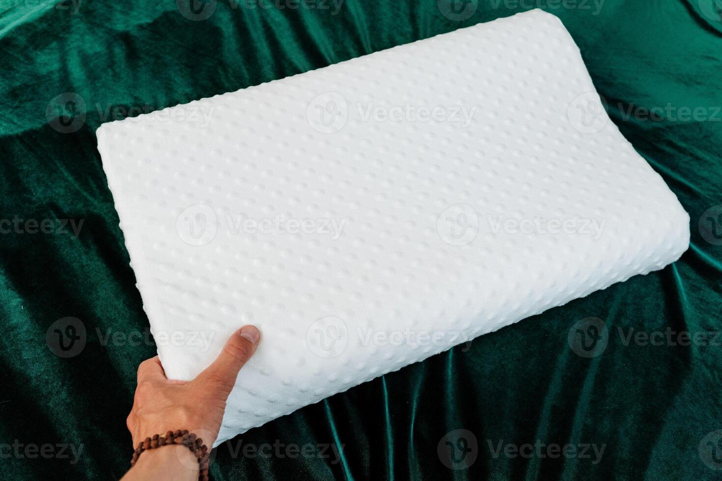 The bed features a white cushion surrounded by green fabrics, gestures, thumbs, sports clothes, grass, and patterns, creating a vibrant and dynamic atmosphere in the room photo