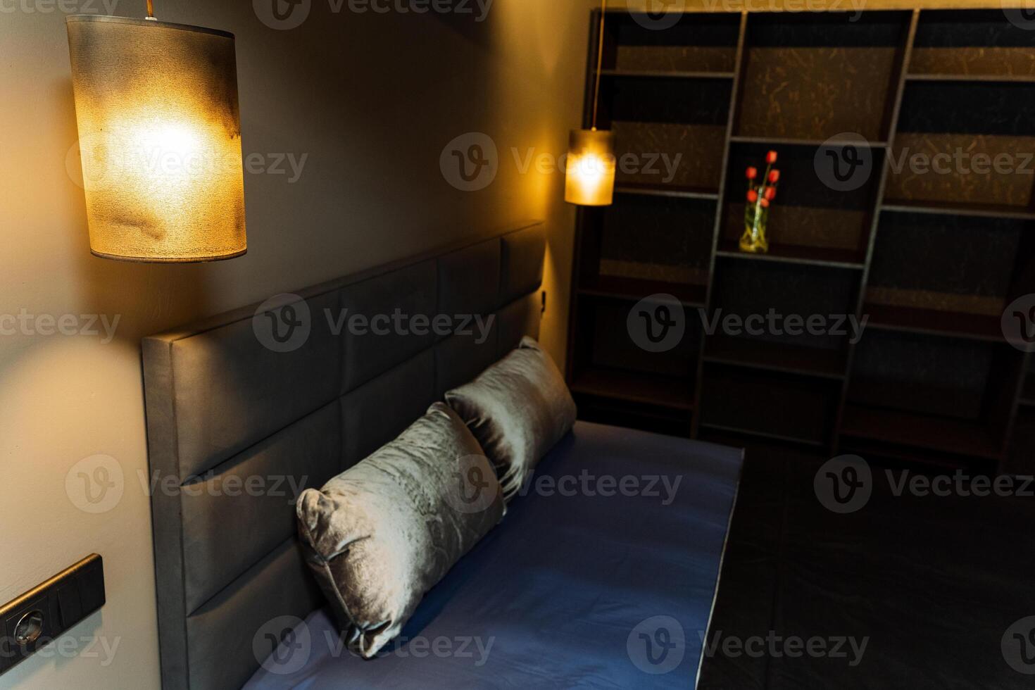 The bedroom features a comfortable bed and a stylish wallmounted lamp, creating a cozy atmosphere that beckons relaxation and rest, perfect for unwinding after a long day photo