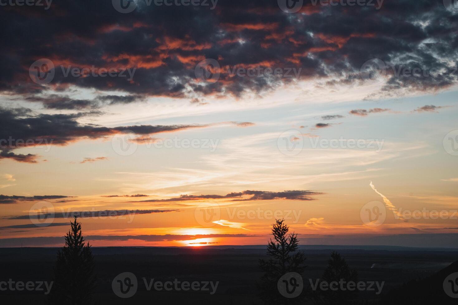 Experience the breathtaking beauty of a stunning sunset casting vibrant colors over rolling hills, creating a tranquil evening landscape photo