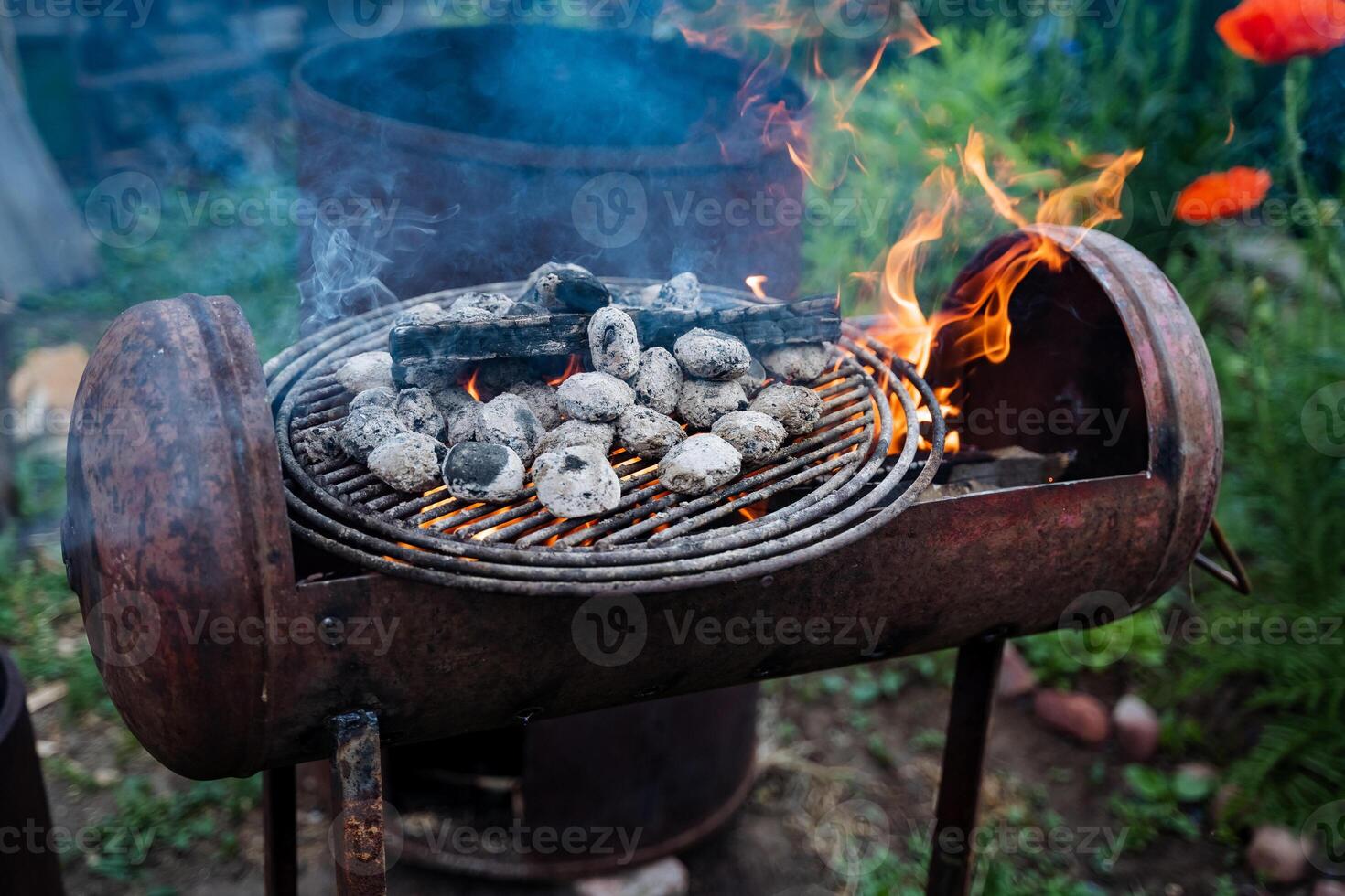 A barrel repurposed as a BBQ grill is being used to cook food outdoors, serving its purpose well by preparing tasty meals. The grill is a versatile cooking tool for meat and other cuisine photo
