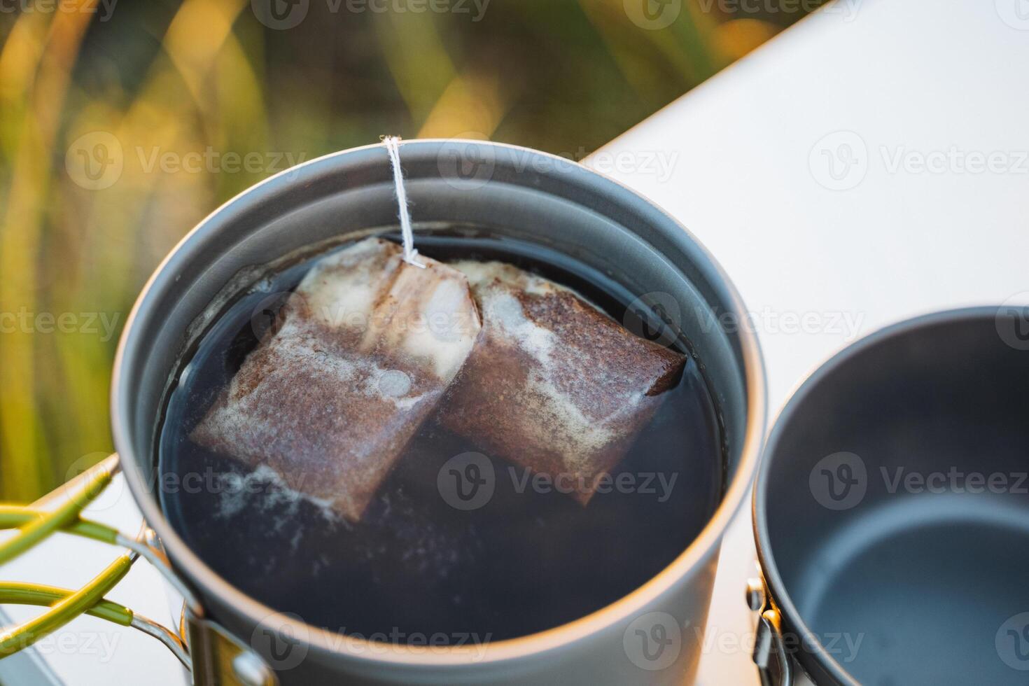 Enjoy a steaming cup of tea as tea bags infuse in warm water, creating a delightful aroma that enhances any gathering with friends photo