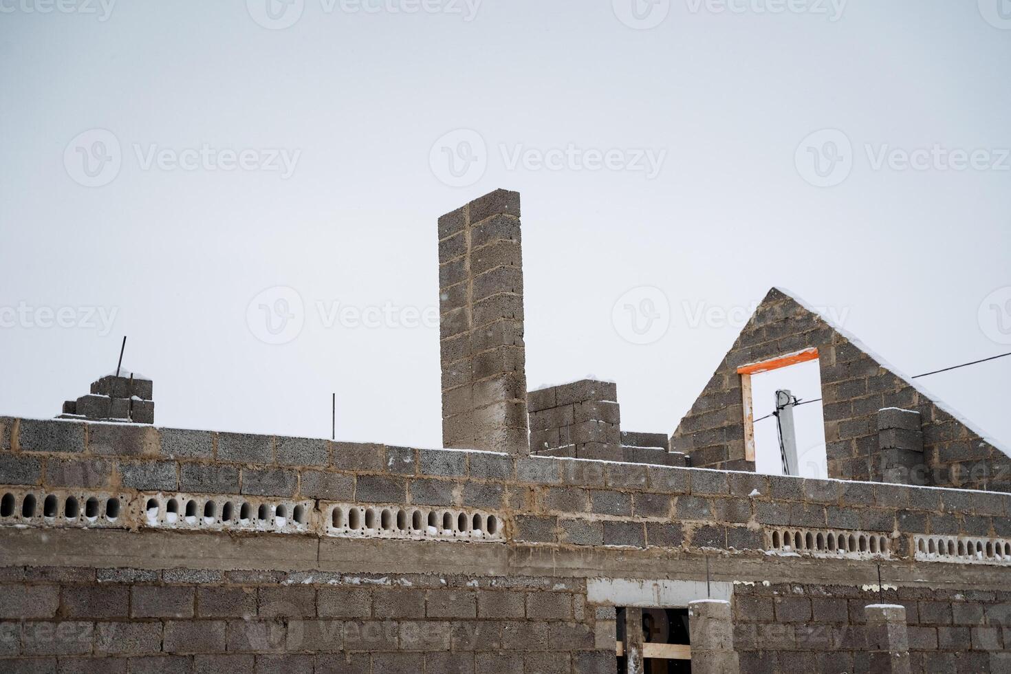 A new building is currently being constructed using bricks along with chimneys as essential features of the architectural design, emphasizing overall aesthetic and functionality photo