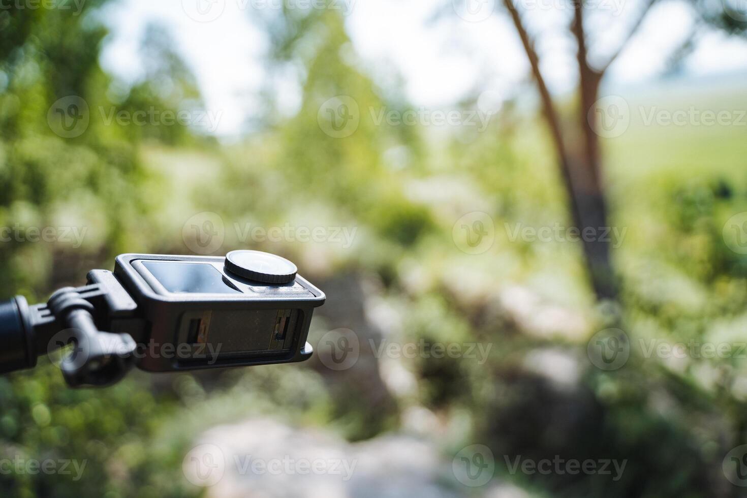 A camera, securely mounted on a stable tripod, captures the beauty of a forest with intricate details, highlighting its serene ambiance and showcasing the stunning natural landscape photo