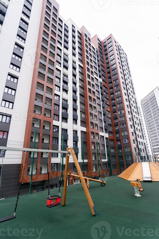 A large, multistory building that stands prominently in the area, with a playground situated in front of it, offering a space for children to play and enjoy recreational activities photo