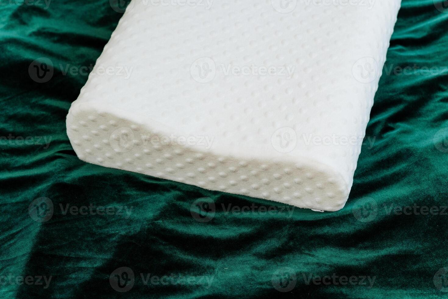 A white pillow is placed on a green blanket, forming a cozy and relaxing space. It emits comfort and tranquility, providing a soothing place to unwind and rest peacefully photo